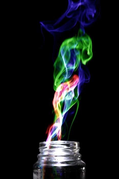 Multi Colored smoke coming from a glass jar, on black background. Achieved by the 'Harris effect' creative photography projects.
