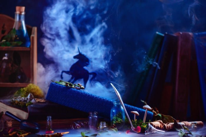 Still life smoke photography featuring glass bottles with the silhouettes of a unicorn and billowing smoke behind