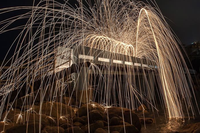 Atmospheric and exciting example of steel wool photography around a building at night 