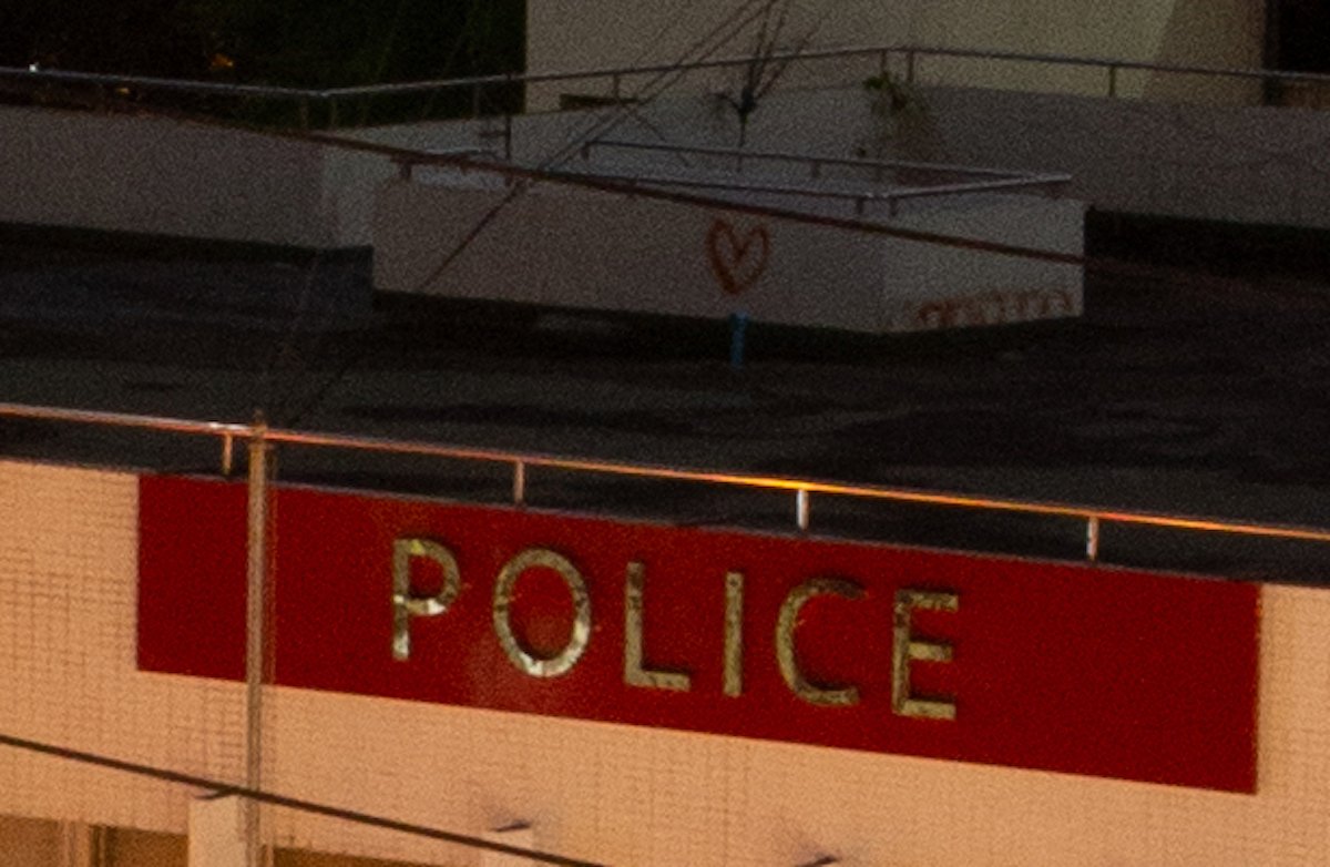 Unedited image of rooftop and police sign in Adobe Lightroom