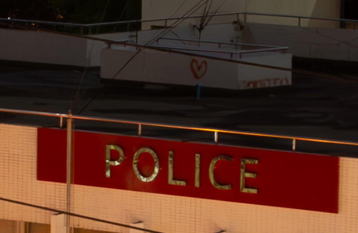 Denoised image of rooftop and police sign in Adobe Lightroom