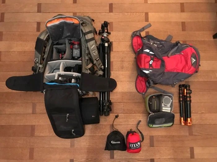 Two camera bags with camera equipment laid out on the floor