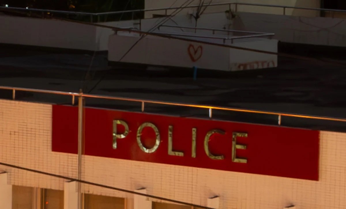 Lightroom Noise-reduced image of rooftop and police sign