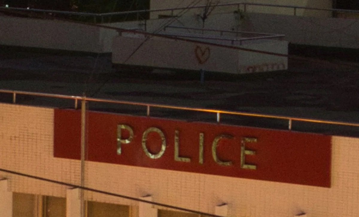 Unedited image of rooftop and police sign