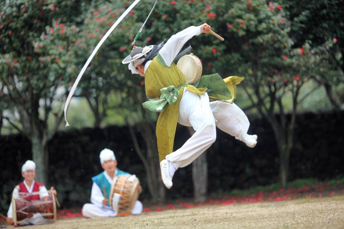 A traditional dancer in mid air - wide vs narrow aperture