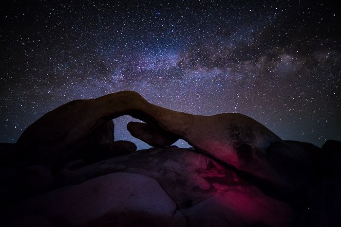 A rock formation in the foreground of a stunning view of the milky way