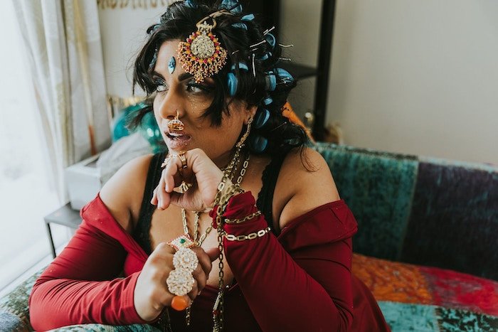 A portrait of a desi woman with intricate jewellery and a nose piercing