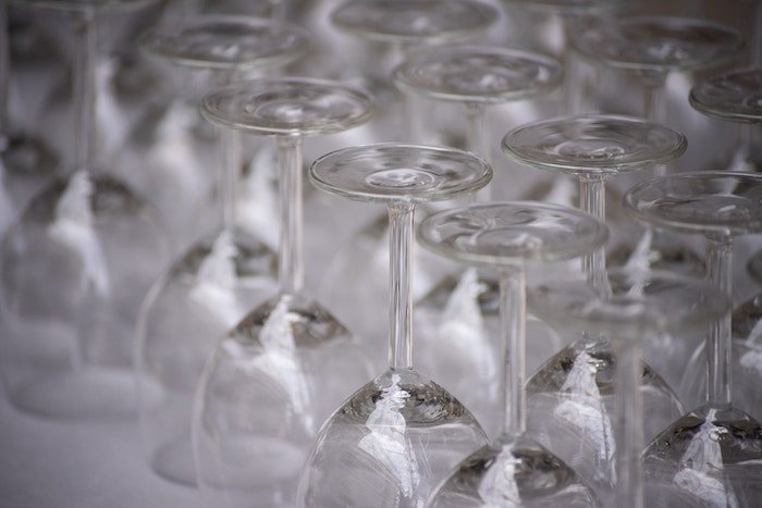 Cropped images of upside-down wine glasses lined up diagonally in the frame
