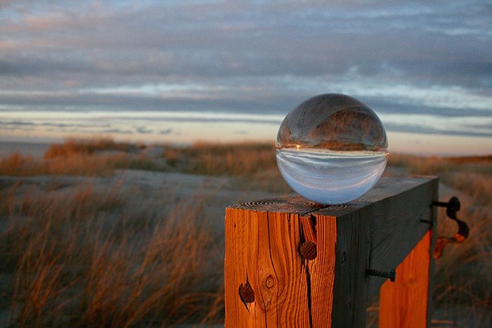 A beautiful landscape at sunset is reflecting in a crystal ball.