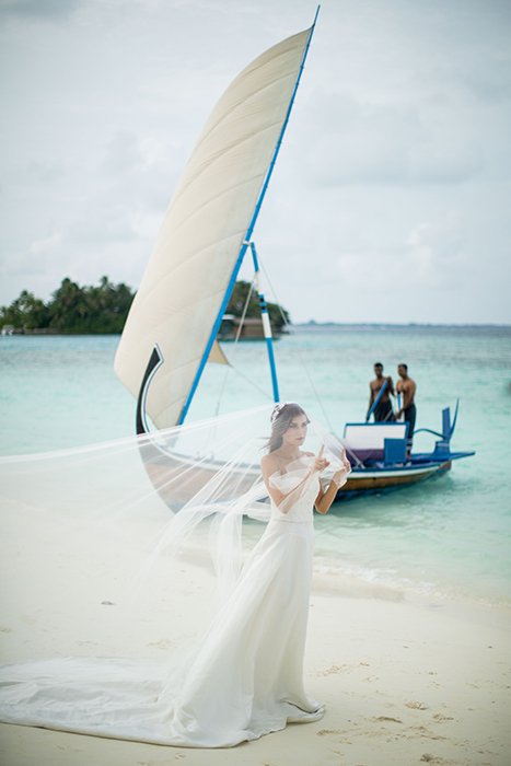 A bride posing with a boat in the background 