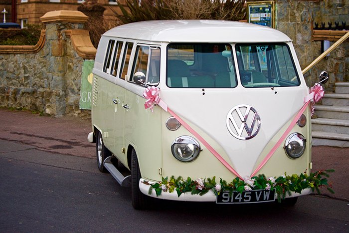 a VW camper van decorated with flowers and ribbons